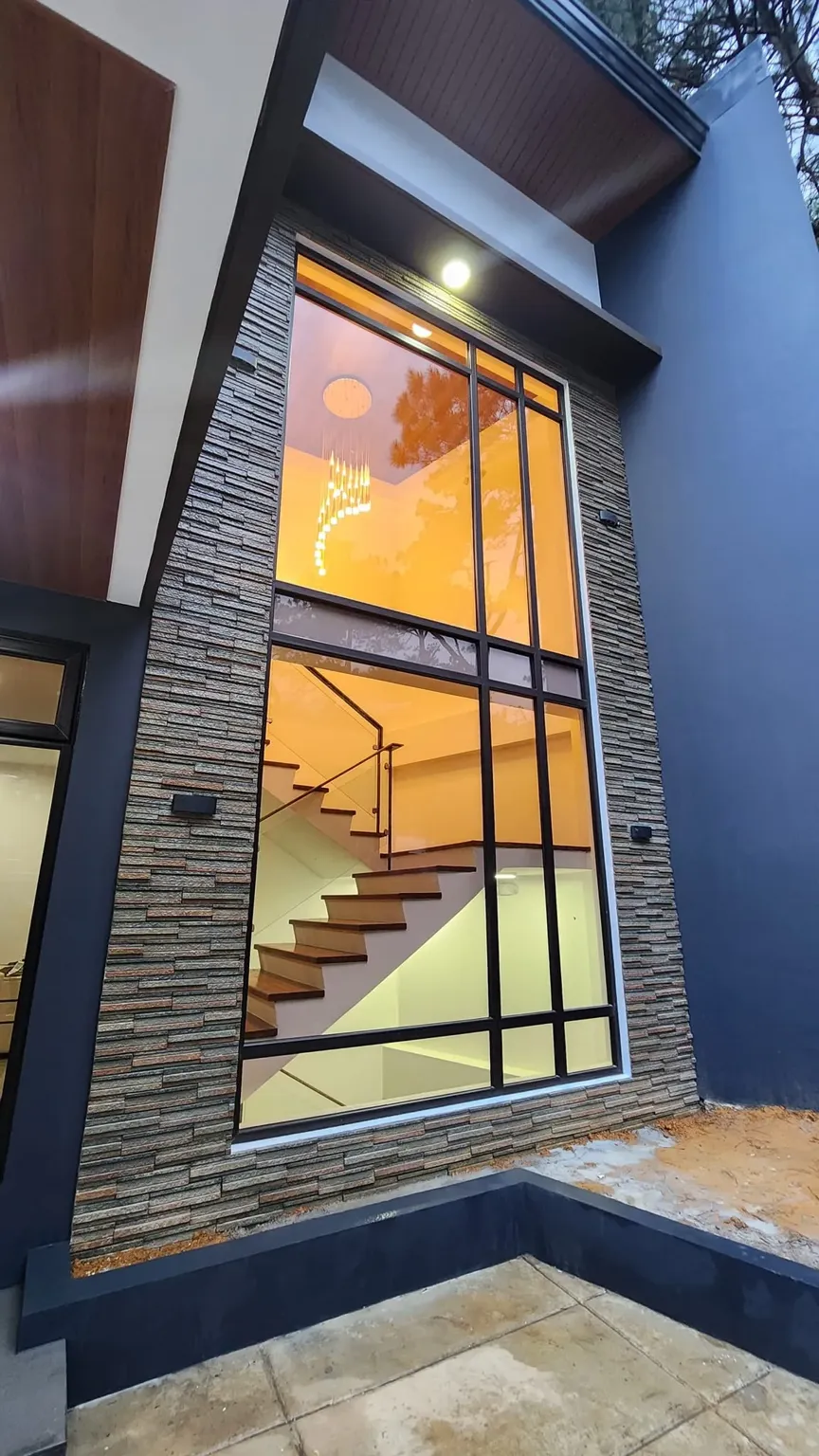 An exterior view of a part of a house that showcases the uPVC windows with dark frames from Vignorth Builders